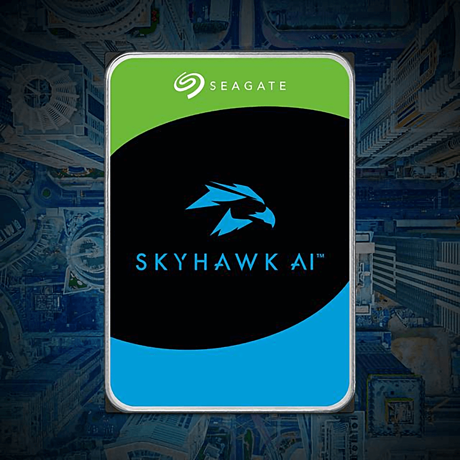 A Seagate SkyHawk AI hard drive features a green and black label with a blue hawk logo. Set against an aerial cityscape background.